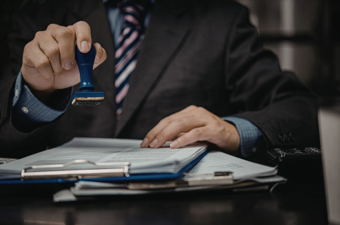 homme en costume qui valide des documents