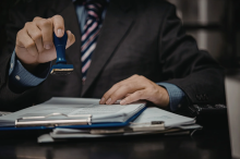 homme en costume qui valide des documents