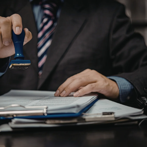 homme en costume qui valide des documents